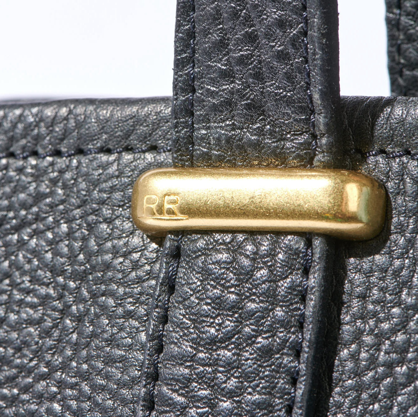 Premium full-grain leather tote shown with laptop and daily essentials