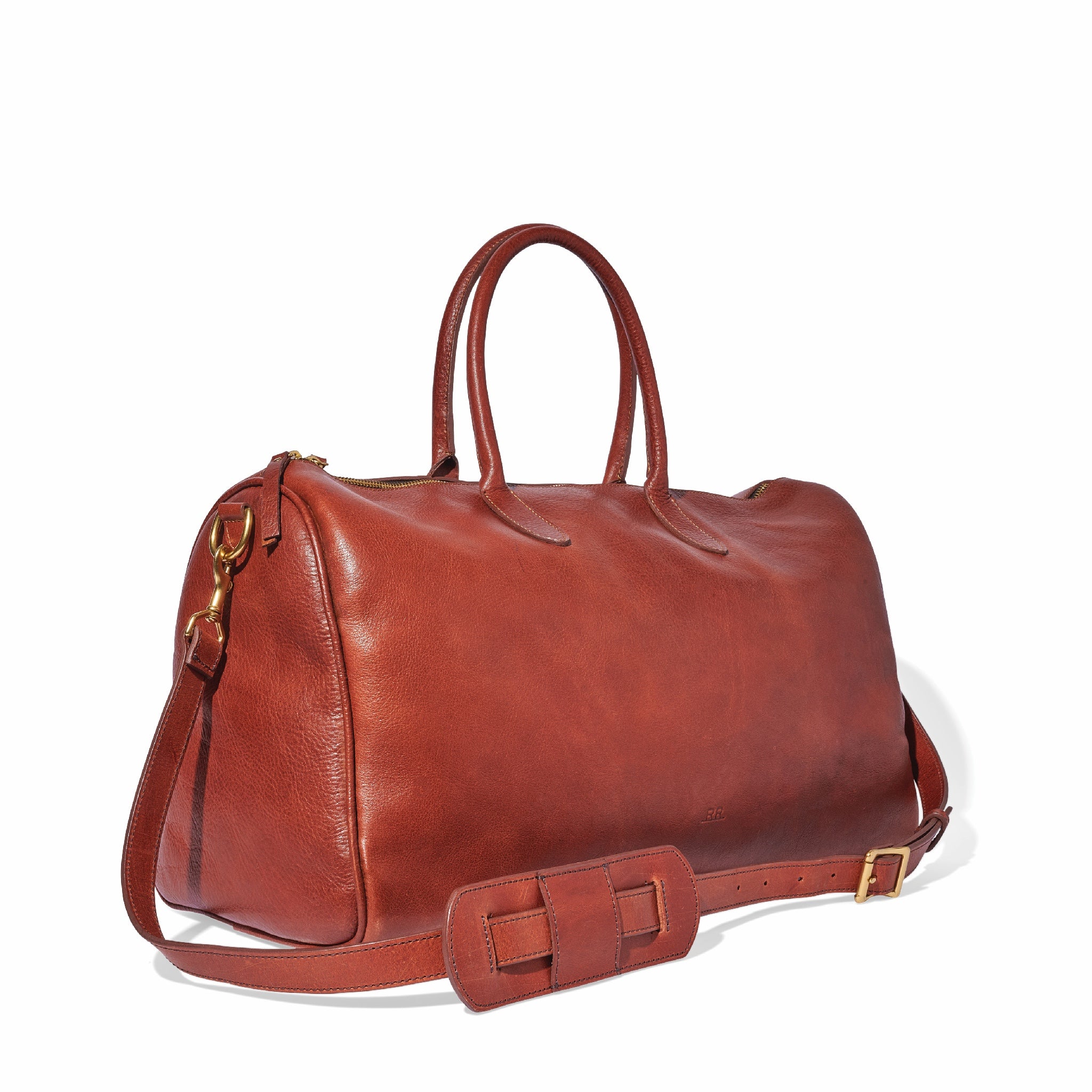 Mahogany brown leather duffle shown packed for stylish weekend travel